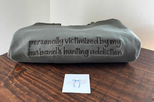 “Personally Victimized by My Husband’s Hunting Addiction” Embroidered Sweatshirt